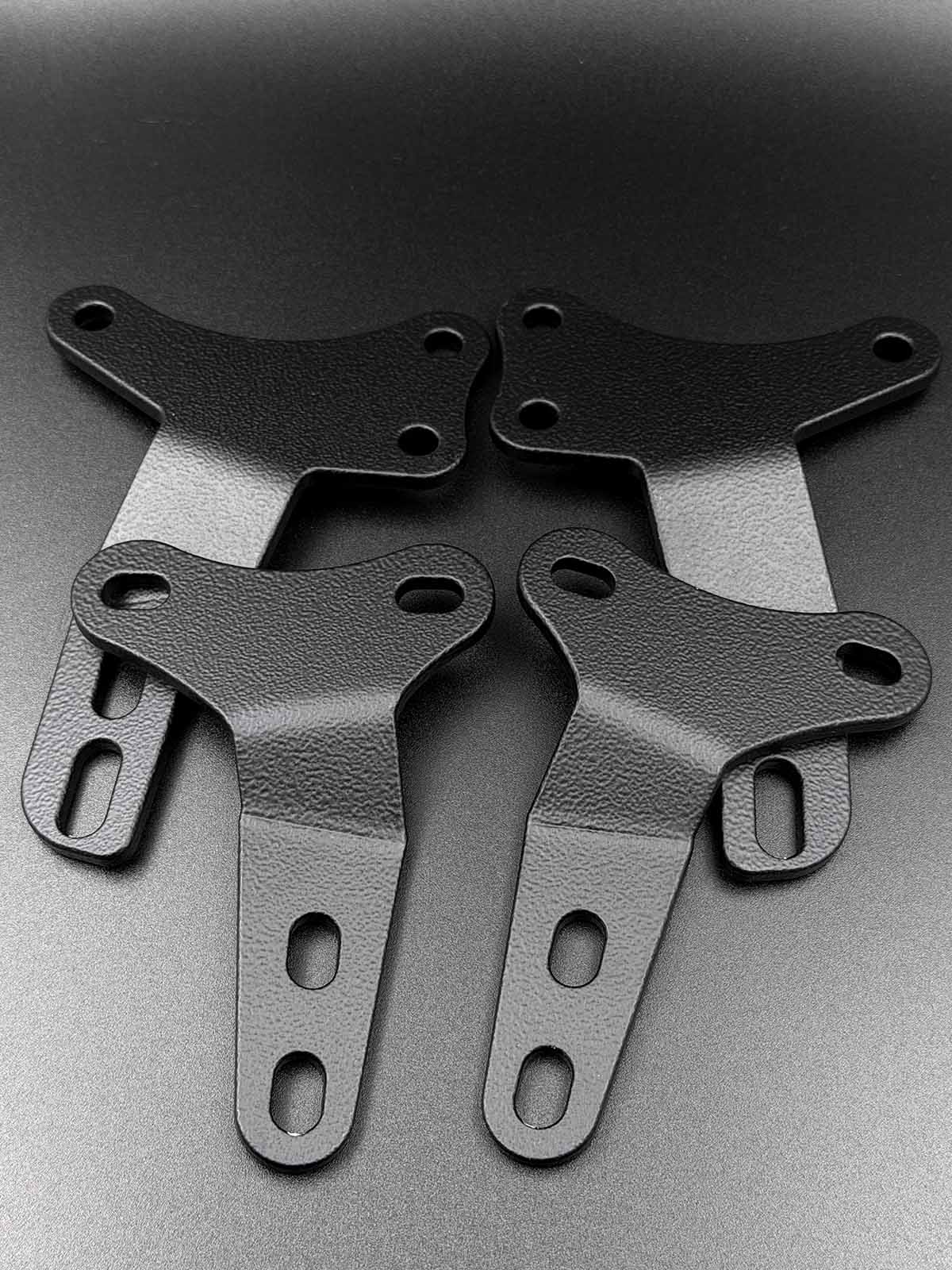 four black hardtop brackets to suit mazda mx-5 hardtop displayed on black textured background.