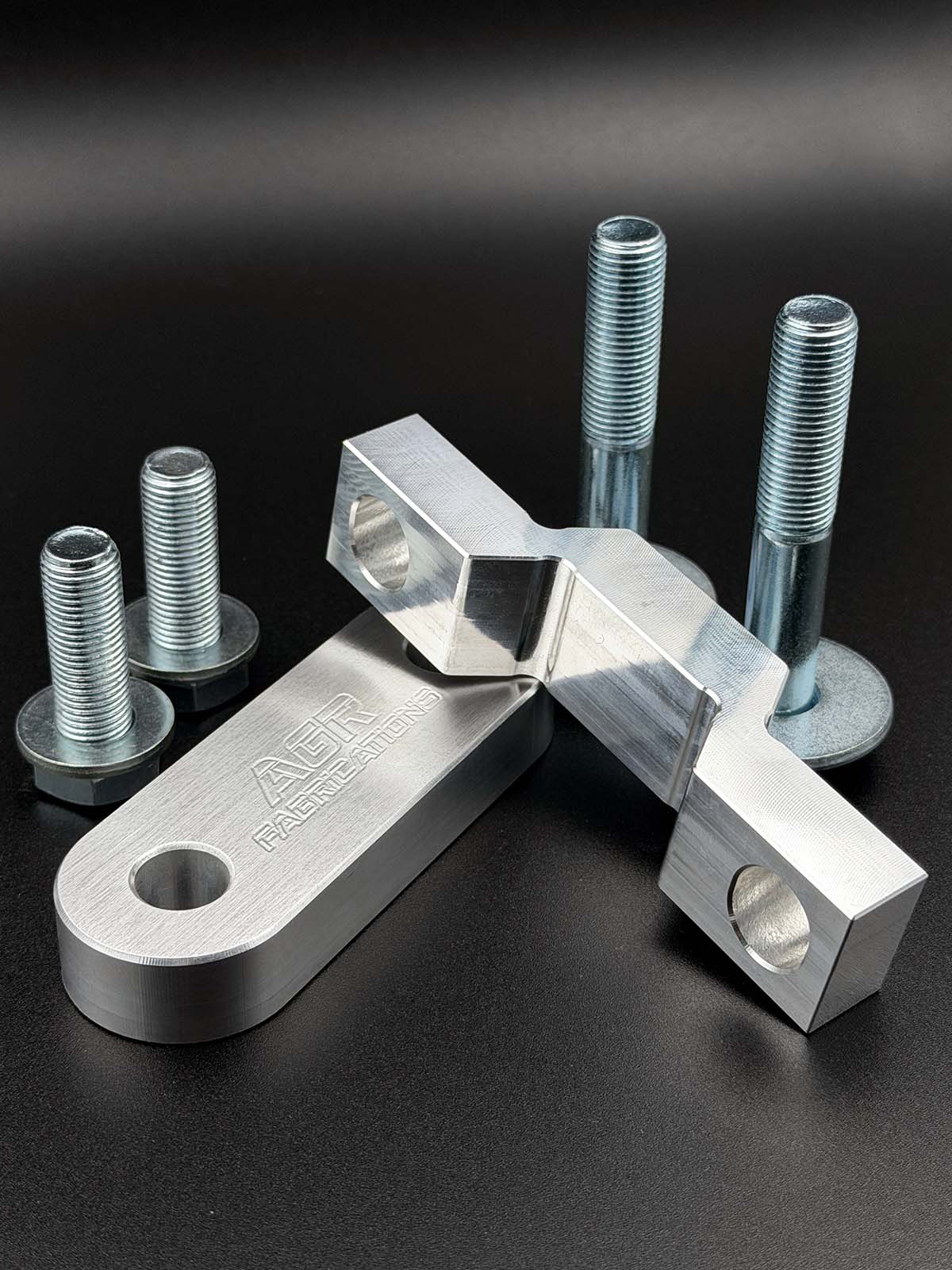 aluminium alloy steering rack spacers displayed on a black background with zinc plated fasteners 